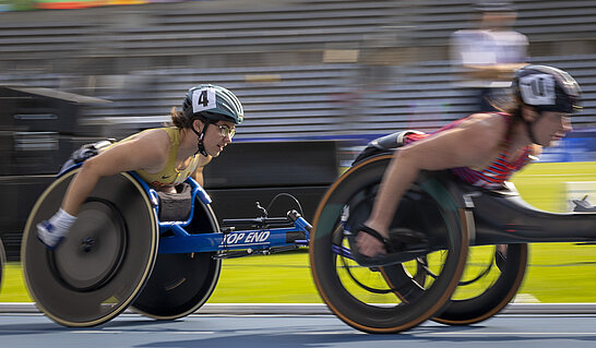 Zwei Athletinnen fahren hintereinander auf dem Handbike